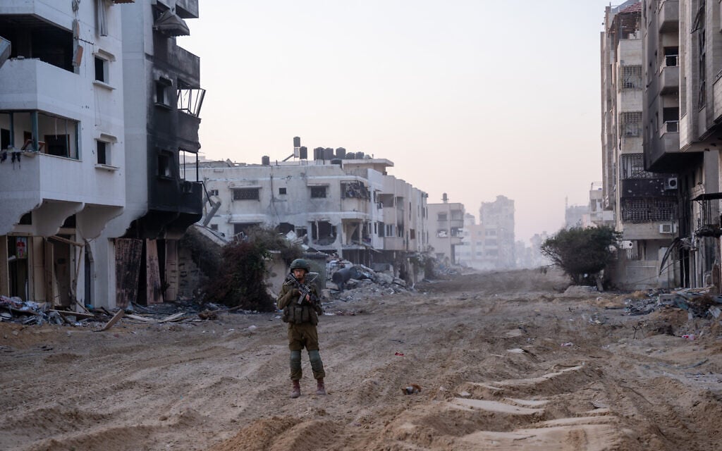 An IDF soldier stands guard near Palestine Square in Gaza City's Rimal neighborhood, December 19, 2023. (Emanuel Fabian/Times of Israel)
