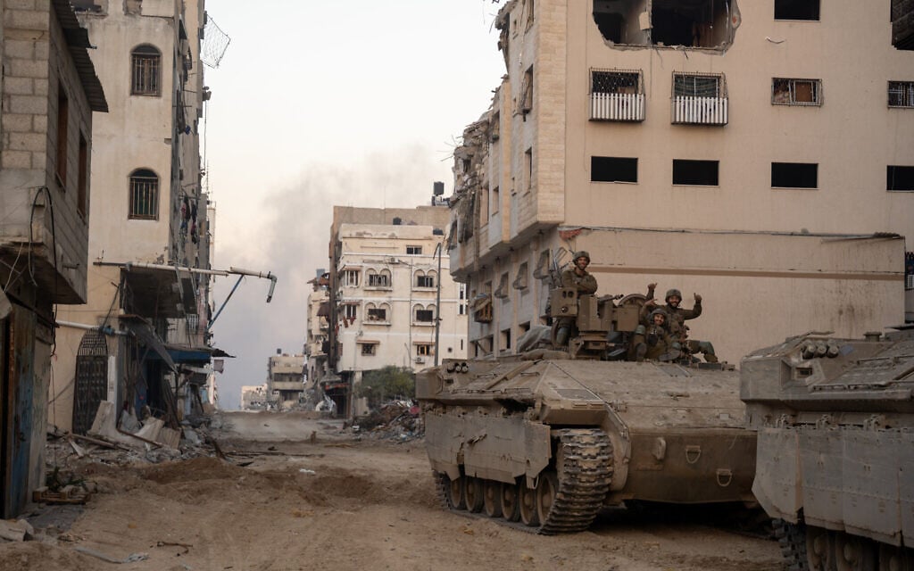 Israeli soldiers are seen on a Namer APC near Palestine Square in Gaza City's Rimal neighborhood, December 19, 2023. (Emanuel Fabian/Times of Israel)