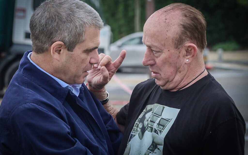 Gal Hirsch, the government's point man on missing and kidnapped citizens, left, speaks to a relative of a captive Israeli ahead of a meeting with families of Israelis held hostage by Hamas terrorists in Gaza and Israelis who were released from Hamas captivity in Herzliya, December 5, 2023. (Avshalom Sassoni/Flash90)