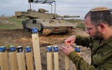 An Israeli soldier lights candles on the second night of the Jewish holiday of Hanukkah near the Israeli border with Syria, December 8, 2023. (Michael Giladi/Flash90)