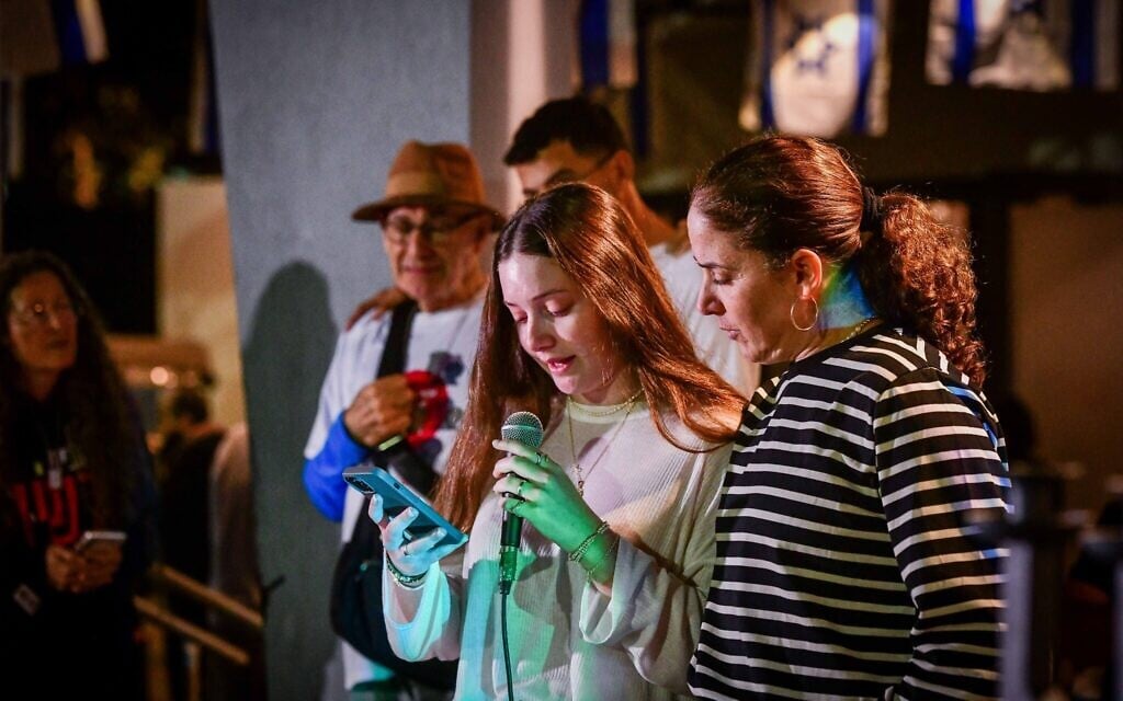 Chen Goldstein-Almog and her daughter Agam, who on Novemner 26, 2023 were released from captivity in Gaza, light Hanukkah candles together with members of their Kibbutz Kfar Aza at a hotel in Shefayim, central Israel, on December 10, 2023. (Avshalom Sassoni/Flash90)