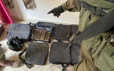 An IDF soldier points to what the army says is an explosive vest adaptable for use by a child, which was uncovered by troops in northern Gaza on December 24, 2023. (Israel Defense Forces)