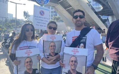 Three cousins of hostage Tsahi Idan stand in front of Defense Ministry compound in Tel Aviv, a new location for families of hostages held in Gaza, on December 19, 2023 (Jessica Steinberg/Times of Israel)