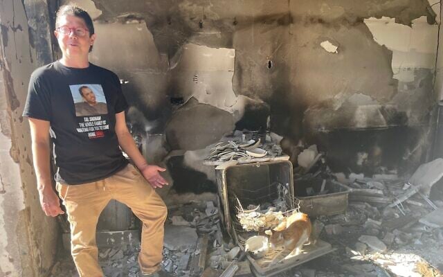 Yuval Haran, whose father was killed and seven of whose family members were taken hostage to Gaza on October 7 from Kibbutz Be'eri, stands in the rubble of his parents' home. (Jessica Steinberg/ Times of Israel)