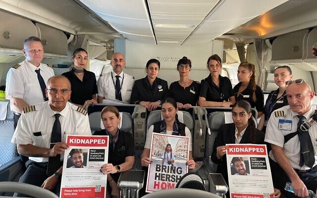 El Al pilots, flight crew hold posters of Gaza captive Hersh Goldberg-Polin, who was supposed to travel to India on the December 27 flight, December 27, 2023.  (Courtesy Shanie Roth)
