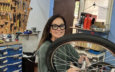 Zippy Schrager assembling a bicycle in Mailiya, a Christian Arab village in the hills of the Western Galilee, December 2023. (Diana Bletter)