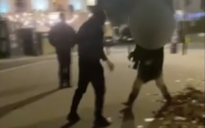 Israelis putting up signs of hostages held by Hamas in Gaza are attacked on the streets of London, in cellphone footage published by Channel 12, December 22, 2023. (Screenshot, used in accordance with Clause 27a of the Copyright Law)