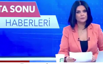 Turkish news anchor Meltem Günay presenting the news on December 24, 2023, accompanied by a Starbucks coffee cup many Turkish viewers found offensive, leading to the anchor's dismissal. Screen capture: TGRT. Used in accordance with Clause 27a of the Copyright Law.