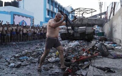 An apparent Hamas member with his hands up hands over an assault rifle after surrendering to troops in northern Gaza's Jabaliya, on December 9, 2023. (Social media: used in accordance with Clause 27a of the Copyright Law)