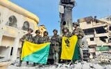 Troops of the Golani Brigade's 13th Battalion stand by a Hamas monument at the Palestine Square in Gaza City's Shejaiya neighborhood, December 18, 2023. (Israel Defense Forces)