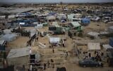 Palestinians displaced by the Israel-Hamas war in the Gaza Strip set up a tent camp in the al-Mawasi area designated by the IDF as a humanitarian zone, December 7, 2023. (AP Photo/Fatima Shbair)