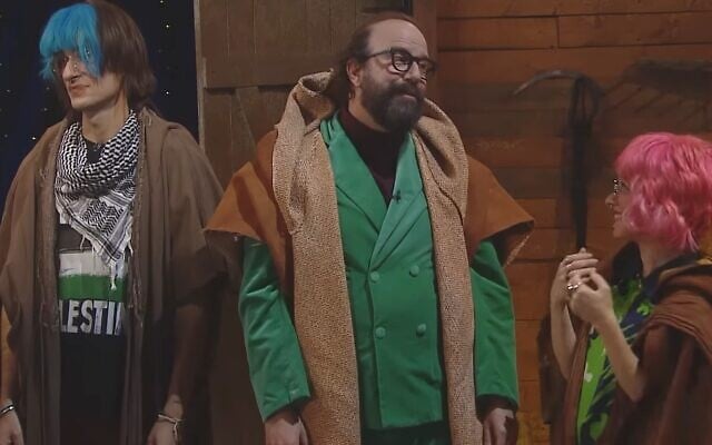 Tamir Bar (L), Liat Harlev (R), and Brett Gelman (C), in their roles as two Berkley students and their professor, on sketch comedy show "Eretz Nehederet," December 27, 2023. Screen capture: Eretz Nehederet, Channel 12. Used in accordance with Clause 27a of the Copyright Law. Tamir Bar (L), Liat Harlev (R), and Brett Gelman (C), in their roles as two Berkley students and their professor, on sketch comedy show "Eretz Nehederet," December 27, 2023. Screen capture: Eretz Nehederet, Channel 12. Used in accordance with Clause 27a of the Copyright Law.
