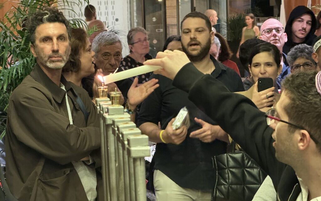 Members of Kibbutz Miflasim light Hankkah candles at the Dan Accadia Hotel in Herzliya, central on December 8, 2023, (Courtesy of the Cultural Section of Kibbutz Miflasim)