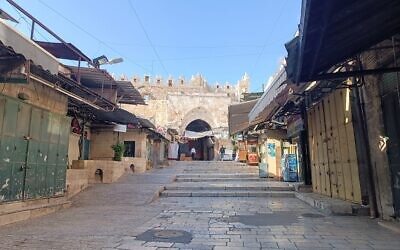 VIew of the commercial street leading to the Damascus Gate inside the Old City of Jerusalem, usually a bustling site with a food market, lying empty during a general strike in solidarity with Palestinians in Gaza, December 11, 2023 (Gianluca Pacchiani / Times of Israel)