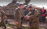 Maj. Idan (right), deputy commander of the Givati Brigade's Rotem Battalion, returns a wallet and dog tag that Yedid Ackerman (left) lost during the 2014 Israel Hamas war (Ynet video screenshot; used in accordance with Clause 27a of the Copyright Law)