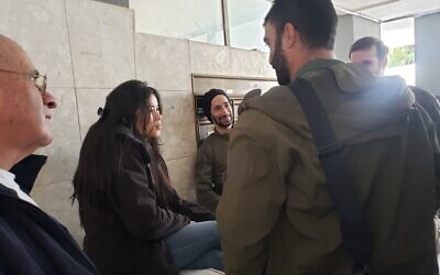 Daniela Garin with her late husband's friends from the army as she mourns him in Tel Aviv on January 29, 2024. (Maya Zanger-Nadis/ToI)