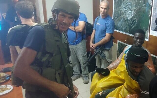 Gabo Altmark (in the blue shirt) along with other members of the Zikim civil guard and agricultural interns inside a safe room during a rocket alert. (Kwabena Frimpong)