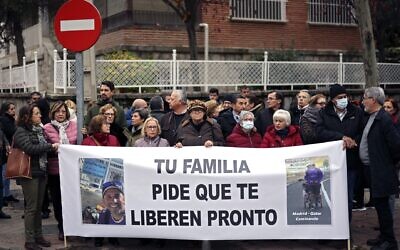 Protesters hold a banner reading 'Your family asks to be released soon' during a rally asking for the freedom of Santiago Sanchez Cogedor, near the Iranian embassy in Madrid, on December 18, 2022. (THOMAS COEX / AFP)