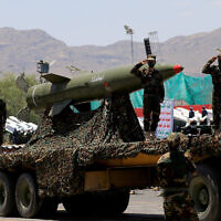 Houthi fighters salute atop a missile carrier during an official military parade marking the ninth anniversary of the Iran-backed rebel group's takeover of the Yemeni capital, Sanaa, on September 21, 2023. (Mohammed Huwais/AFP)