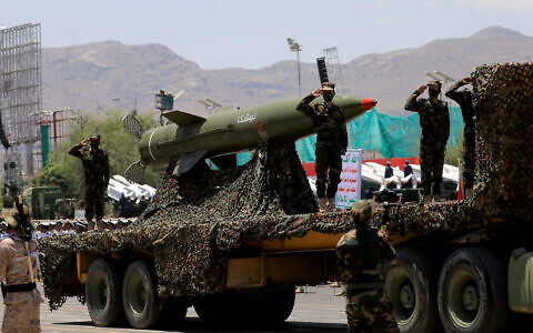 Houthi fighters salute atop a missile carrier during an official military parade marking the ninth anniversary of the Iran-backed rebel group's takeover of the Yemeni capital, Sanaa, on September 21, 2023. (Mohammed Huwais/AFP)