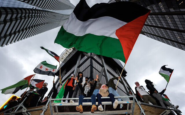 Anti-Israeli demonstrators wave Palestinian flags during a protest in Toronto, Ontario, Canada, October 9, 2023 (Cole Burston / AFP)