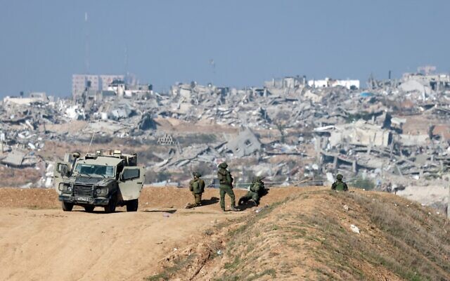This picture taken from the Israeli border with the northern Gaza Strip shows Israeli soldiers watching Gaza City from a position on January 1, 2024, amid the ongoing battles between Israel and the terror group Hamas. (Menahem Kahana/AFP) This picture taken from the Israeli border with the northern Gaza Strip shows Israeli soldiers watching Gaza City from a position on January 1, 2024, amid the ongoing battles between Israel and the terror group Hamas. (Menahem Kahana/AFP)