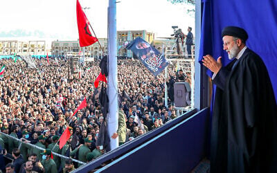 Iran's President Ebrahim Raisi greets mourners after speaking during the funeral of victims killed in twin blasts on January 3, 2024, as they took part in a commemoration marking the anniversary of the killing of Revolutionary Guards general Qassem Soleimani in the southern city of Kerman. (Iranian Presidency / AFP)