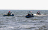 Members of the Yemeni Coast Guard affiliated with the Houthi group patrol the sea with Palestinian flags as demonstrators march through the Red Sea port city of Hodeida, in solidarity with the people of Gaza on January 4, 2024. (AFP)