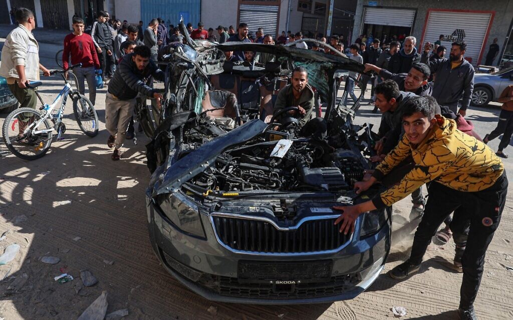 People check the car in which two journalists, Mustafa Thuria and Hamza Wael Dahdouh, were killed in a reported Israeli strike in Rafah in the Gaza Strip on January 7, 2024. (AFP)
