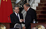 Egyptian Foreign Minister Sameh Shoukry (R) and China's Foreign Minister Wang Yi shake hands during a press conference following a meeting at al-Tahrir Palace in the center of Cairo on January 14, 2024. (Khaled DESOUKI / AFP)