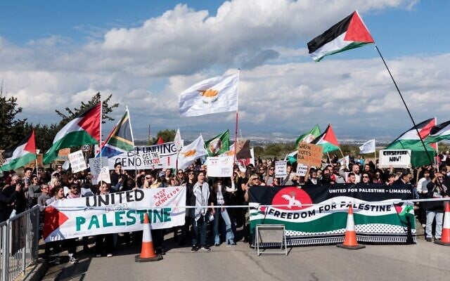 Protesters wave Palestinian flags in front of the gates of the Royal Air Force Akrotiri base near Limassol, Cyprus, on January 14, 2024. (Iakovos Hatzistavrou / AFP)