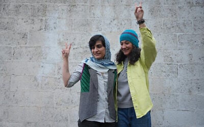 This picture taken and released by the Sharq News Online on January 14, 2024, shows Iranian journalists Niloufar Hamedi (R) and Elaheh Mohammadi (L) flashing the sign of victory after they were released from Evin prison on bail in Tehran. (Photo by Sahand TAKI/Sharq news online/AFP)