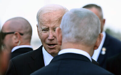 Prime Minister Benjamin Netanyahu (back) greets US President Joe Biden upon his arrival at Ben Gurion International Airport, October 18, 2023. (Brendan Smialowski/ AFP)