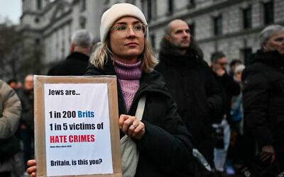 File: Protesters hold placards during a demonstration to protest against antisemitism, in central London on November 26, 2023. (JUSTIN TALLIS / AFP)