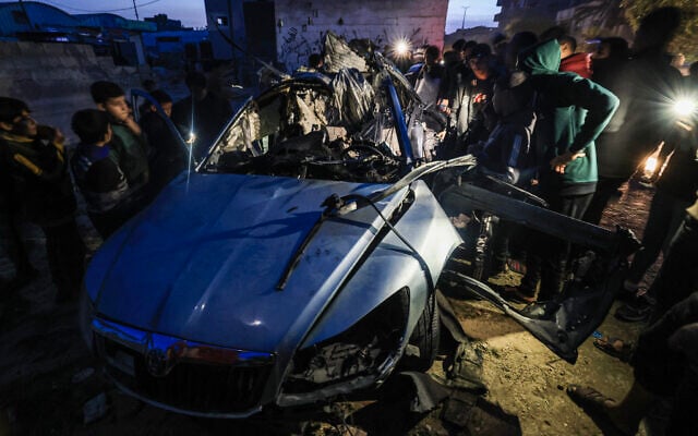 Palestinians inspect the remains of a car reportedly hit by an Israeli strike in Rafah in the southern Gaza Strip on January 20, 2024. (AFP) Palestinians inspect the remains of a car reportedly hit by an Israeli strike in Rafah in the southern Gaza Strip on January 20, 2024. (AFP)