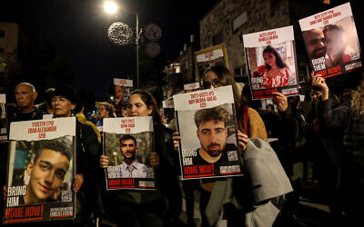 Demonstrators hold up portraits of hostages held by the Hamas terror group during a rally to demand their release, near the Prime Minister's Residence in Jerusalem on January 22, 2024. (Ahmad Gharabli/AFP)
