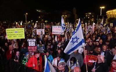 Protesters hold flags and placards during a rally in Tel Aviv on January 27, 2024, demanding the government's resignation and early elections, amid the ongoing war in Gaza. (Ahmad Gharabli/AFP)