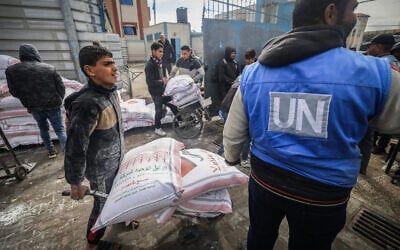 Displaced Palestinians receive food aid at the United Nations Relief and Works Agency for Palestine Refugees (UNRWA) center in Rafah in the southern Gaza Strip on January 28, 2024. (AFP)