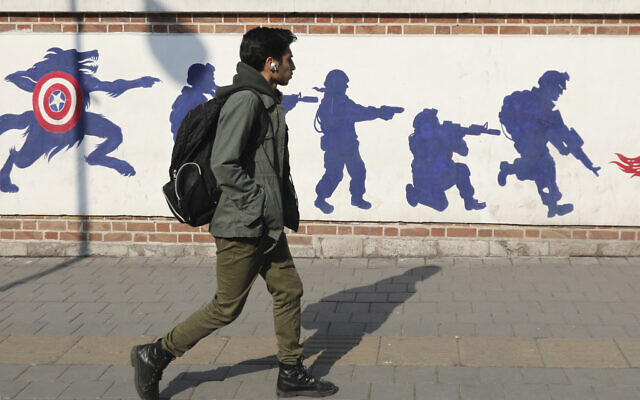 A young man walks past anti-US graffiti outside the building formerly hosting the embassy of the United States in Tehran on January 30, 2024. (Atta Kenare/AFP) A young man walks past anti-US graffiti outside the building formerly hosting the embassy of the United States in Tehran on January 30, 2024. (Atta Kenare/AFP)