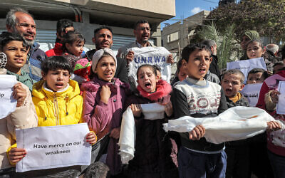 Palestinian men and children gather for a demonstration in Rafah in the southern Gaza Strip on January 30, 2024, calling for continued international support to the United Nations Relief and Works Agency. (AFP)