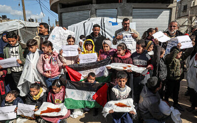 Palestinian men and children gather for a demonstration in Rafah in the southern Gaza Strip on January 30, 2024, calling for continued international support to the United Nations Relief and Works Agency UNRWA. (Photo by AFP)
