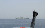 In this image provided by the Iranian Revolutionary Guard via Tasnim News Agency on August 20, 2023, a machine gun's muzzle of a Revolutionary Guard speedboat is seen as the boat moves near USS Bataan at the Strait of Hormuz, in the mouth of the Persian Gulf. (Iranian Revolutionary Guard/Tasnim News Agency via AP)
