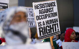 Illustrative: Pro-Palestinian supporters hold up signs during a demonstration, October 20, 2023, in Atlanta, that intimate that the Hamas massacre of 1,200 people on October 7, 2023, was legitimate resistance to 'occupation.' (AP Photo/Mike Stewart)