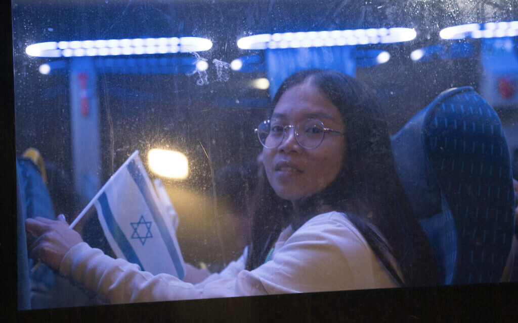 Thai nationals gesture from a bus as they leave the Shamir Hospital in Ramle, Israel, November 29, 2023, on their way back to Thailand, after being kidnapped and held by Hamas terrorists for over six weeks. (AP Photo/Maya Levin)