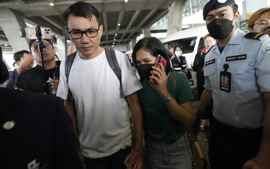 Owat Suriyasri, left, a Thai hostage who was freed after being abducted by Hamas terrorists, holds the hand of his wife Kanyarat Suriyasri on his arrival at Suvarnabhumi International Airport in Samut Prakarn Province, Thailand, December 4, 2023. (AP Photo/Sakchai Lalit)