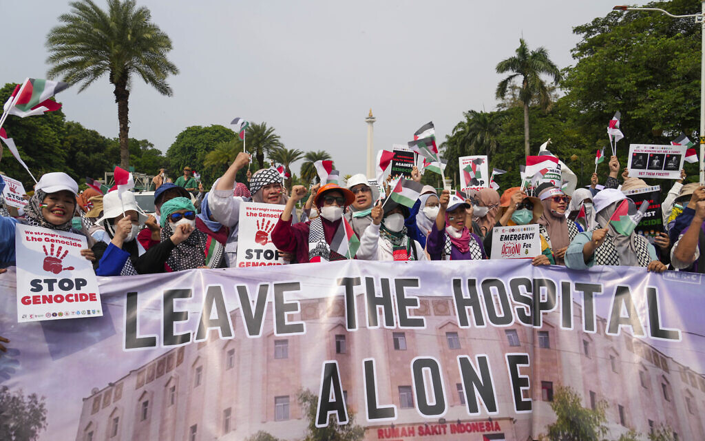 Protesters from several medical workers' associations shout slogans and wave Palestinian flags during an anti-Israel, pro-Palestinian rally in Jakarta, Indonesia, December 15, 2023. (AP Photo/Tatan Syuflana)
