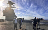 Defense Secretary Lloyd Austin, second right, talks with the commanding officer of the USS Gerald R. Ford, Navy Capt. Rick Burgess, right, during an unannounced visit to the ship on Wednesday, Dec. 20, 2023. The USS Gerald R. Ford has been sailing just a few hundred miles off the coast of Israel to prevent the Israel-Hamas war from expanding into a regional conflict. (AP/Tara Copp)
