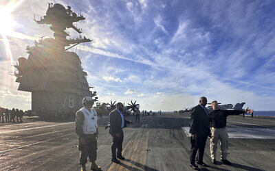 Defense Secretary Lloyd Austin, second right, talks with the commanding officer of the USS Gerald R. Ford, Navy Capt. Rick Burgess, right, during an unannounced visit to the ship on Wednesday, Dec. 20, 2023. The USS Gerald R. Ford has been sailing just a few hundred miles off the coast of Israel to prevent the Israel-Hamas war from expanding into a regional conflict. (AP/Tara Copp)