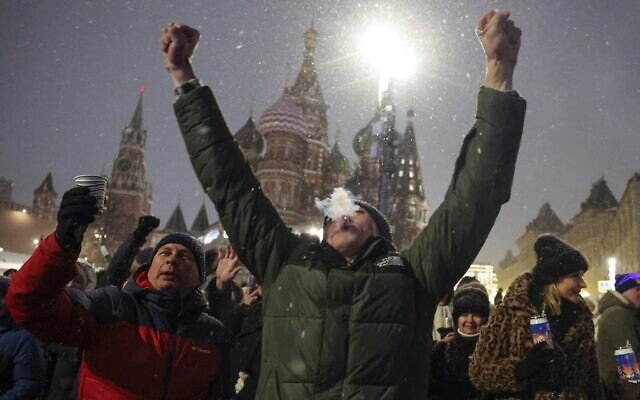 People gather near Red Square with the St. Basil's Cathedral, right, and the Spasskaya Tower, left, in the background, to celebrate the new year after midnight in Moscow, Russia, Monday, Jan. 1, 2024. (AP Photo/Marina Lystseva) People gather near Red Square with the St. Basil's Cathedral, right, and the Spasskaya Tower, left, in the background, to celebrate the new year after midnight in Moscow, Russia, Monday, Jan. 1, 2024. (AP Photo/Marina Lystseva)
