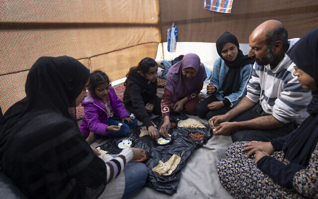 Members of the Abu Jarad family, who were displaced by Israel's war with Hamas in the Gaza Strip, eat breakfast at a makeshift tent camp in the Muwasi area, southern Gaza, Monday, January 1, 2024. (AP Photo/Fatima Shbair) Members of the Abu Jarad family, who were displaced by Israel's war with Hamas in the Gaza Strip, eat breakfast at a makeshift tent camp in the Muwasi area, southern Gaza, Monday, January 1, 2024. (AP Photo/Fatima Shbair)